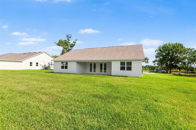 2569 Rogers Rd, Lakeland, FL 33812 - back of house with stucco siding and a yard