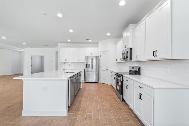 2569 Rogers Rd, Lakeland, FL 33812 - kitchen featuring appliances with stainless steel finishes, recessed lighting, tasteful backsplash, an island with sink, and light wood-style flooring