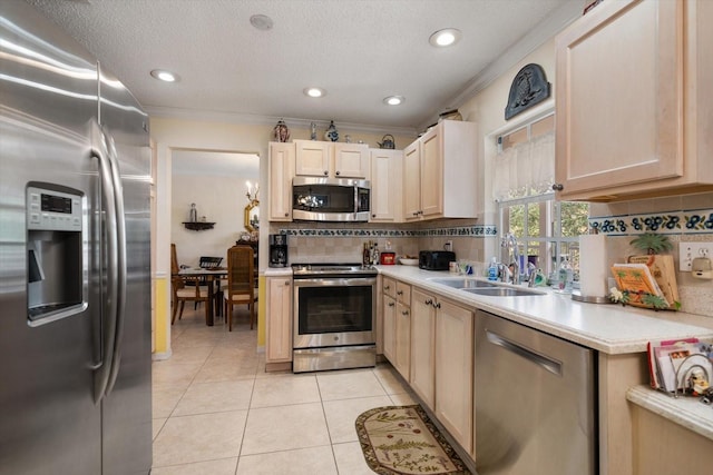 kitchen featuring light tile patterned floors, stainless steel appliances, light countertops, light brown cabinetry, and tasteful backsplash