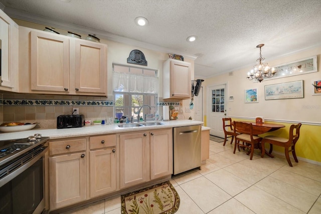 kitchen featuring light brown cabinets, stainless steel appliances, a sink, and crown molding