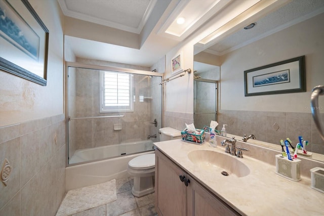 bathroom featuring toilet, shower / bath combination with glass door, ornamental molding, vanity, and tile walls