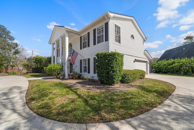 view of home's exterior featuring a garage, concrete driveway, and a lawn