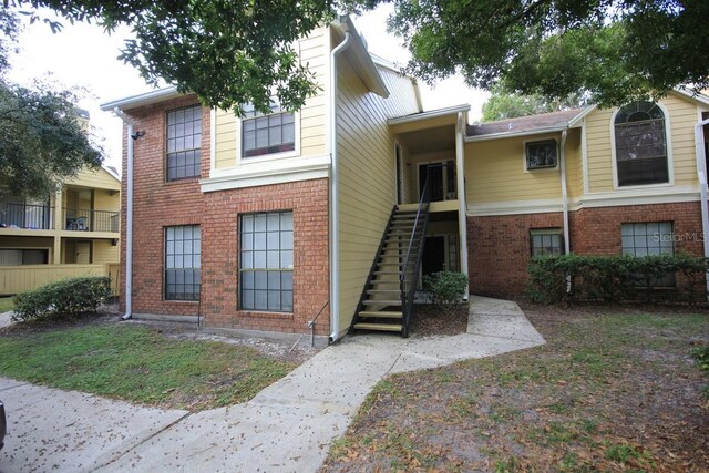 view of front of property featuring brick siding and stairs