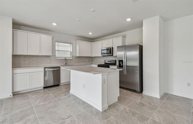 10352 Cross River Trl, Parrish, FL 34219 - kitchen featuring appliances with stainless steel finishes, white cabinetry, light countertops, backsplash, and a center island