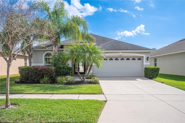 view of front of home featuring a garage, driveway, a front yard, and stucco siding