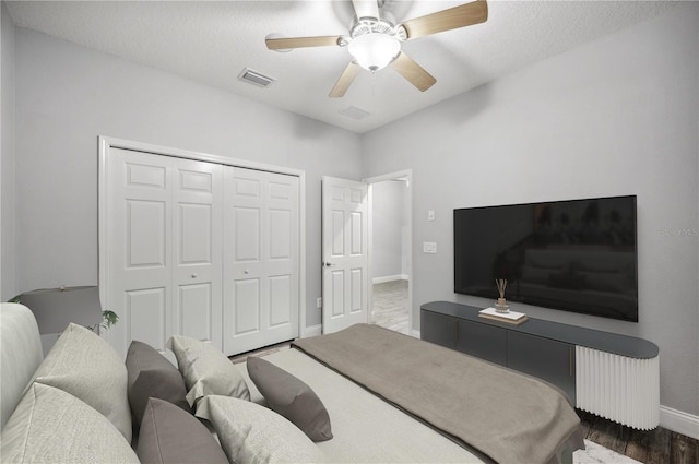 bedroom featuring a closet, visible vents, radiator heating unit, ceiling fan, and baseboards