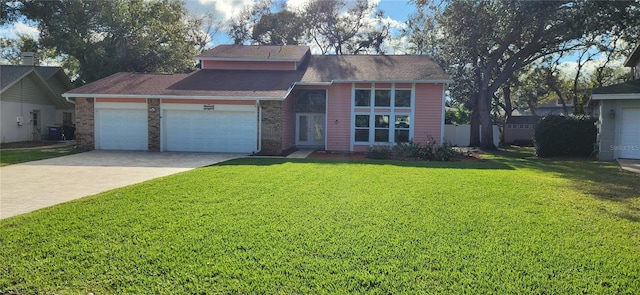 view of front of home featuring a garage, brick siding, driveway, and a front yard