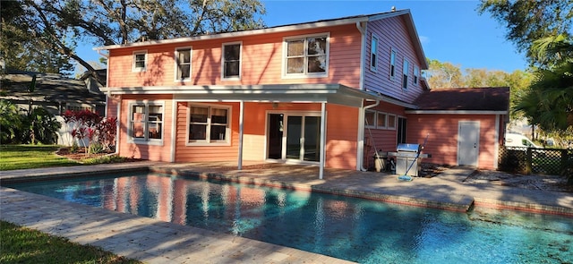 back of property featuring a patio area, fence, and an outdoor pool