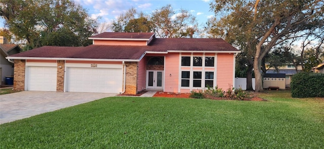 view of front of home with a garage, a front yard, decorative driveway, and brick siding