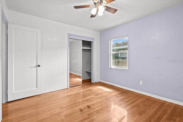 unfurnished bedroom featuring light wood-type flooring, ceiling fan, baseboards, and a closet