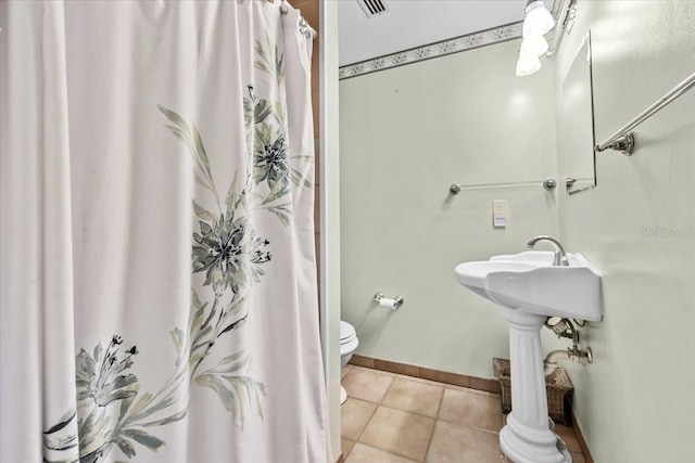 full bath featuring a shower with shower curtain, baseboards, toilet, and tile patterned floors