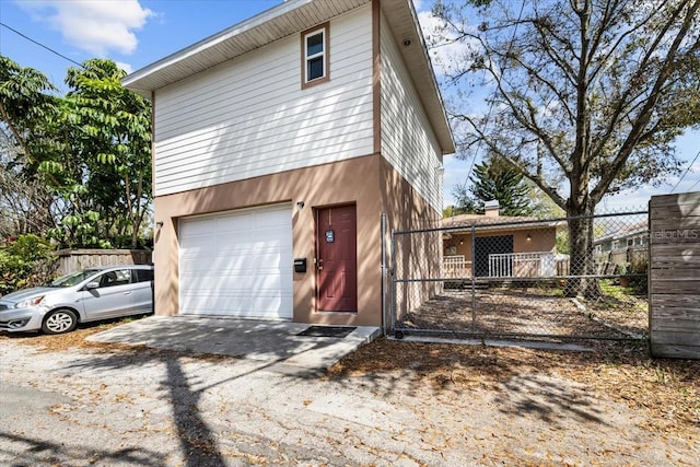 exterior space with a garage, stucco siding, fence, and aphalt driveway