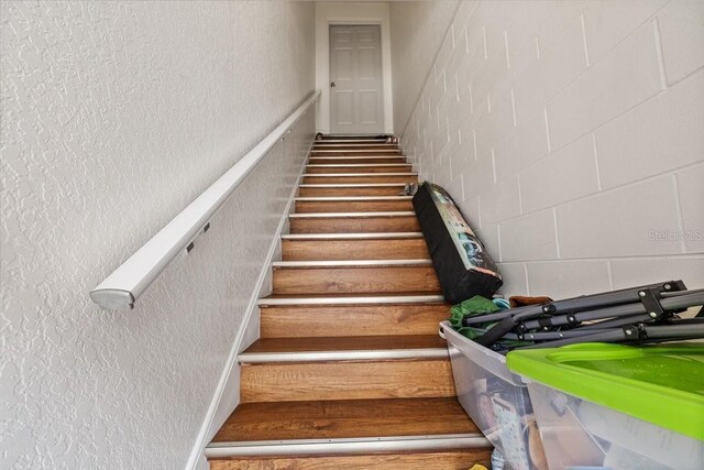 staircase featuring a textured wall