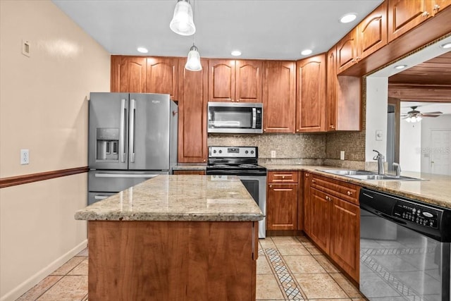 kitchen featuring light stone counters, backsplash, a kitchen island, stainless steel appliances, and a sink