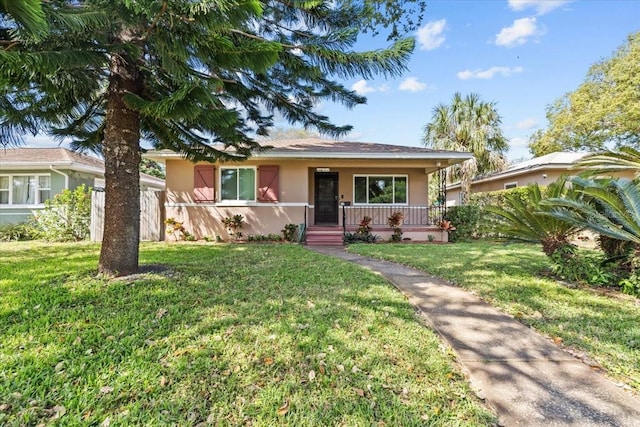 view of front facade featuring stucco siding, a front lawn, and covered porch