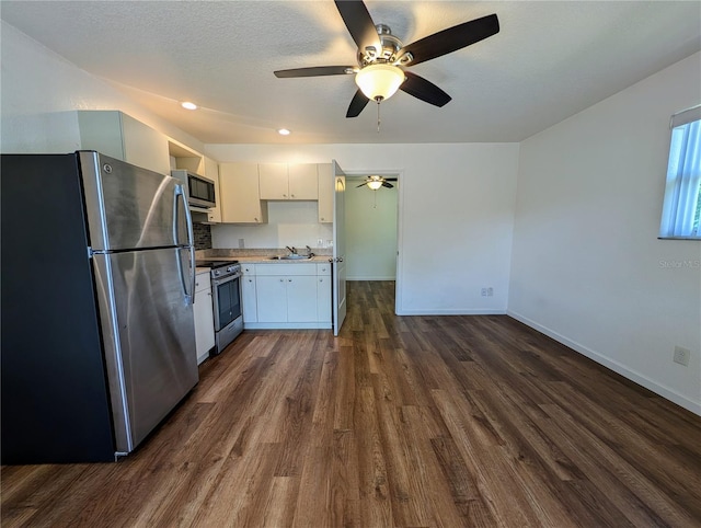 kitchen featuring dark wood finished floors, a ceiling fan, light countertops, stainless steel appliances, and baseboards