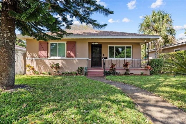 view of front of property with a front lawn, covered porch, and stucco siding