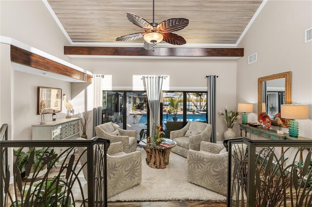 living room with ceiling fan, visible vents, and ornamental molding