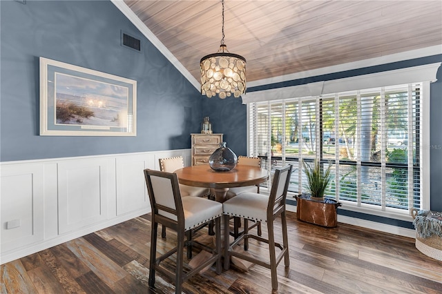 dining room featuring visible vents, crown molding, dark wood-type flooring, and vaulted ceiling