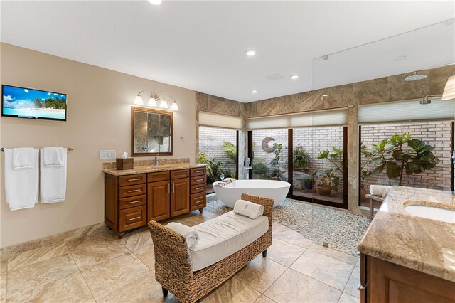 bathroom with a soaking tub, two vanities, recessed lighting, and a sink