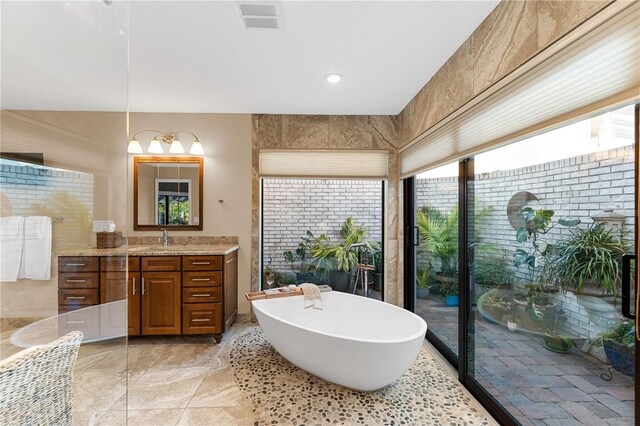 full bathroom with visible vents, a freestanding bath, and vanity