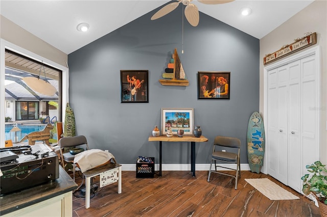 home office featuring vaulted ceiling, baseboards, dark wood-type flooring, and ceiling fan