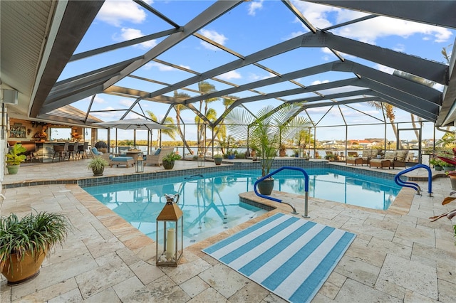 outdoor pool with glass enclosure, outdoor dry bar, and a patio area