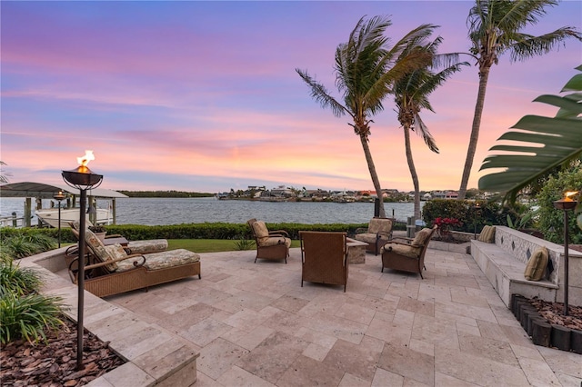 view of patio / terrace with an outdoor living space with a fire pit and a water view