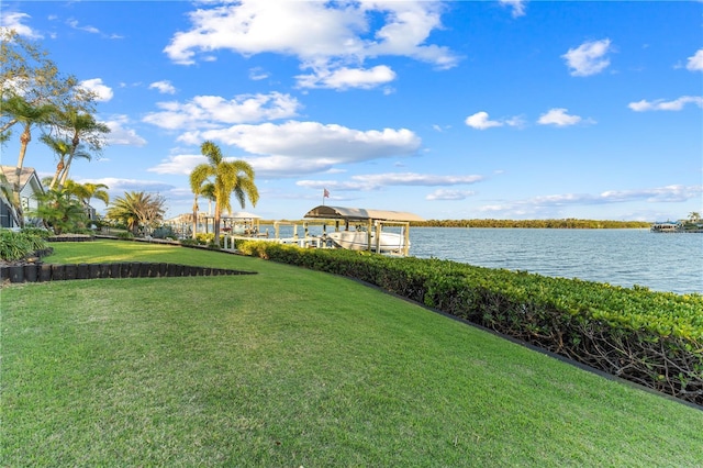 view of yard featuring boat lift, a boat dock, and a water view