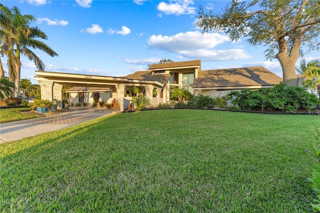 view of front of home featuring decorative driveway and a front yard