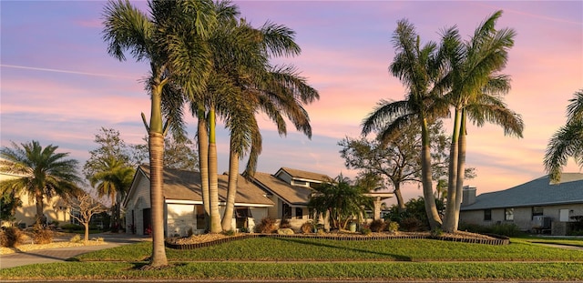 view of front of property with decorative driveway, central air condition unit, and a front yard