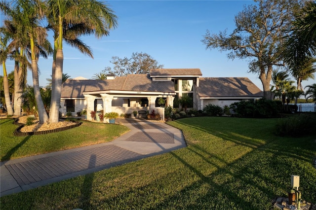 view of front of property with a tiled roof and a front lawn