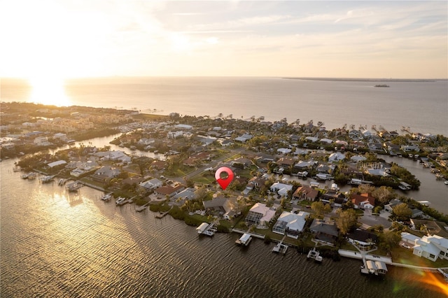 aerial view at dusk featuring a residential view and a water view