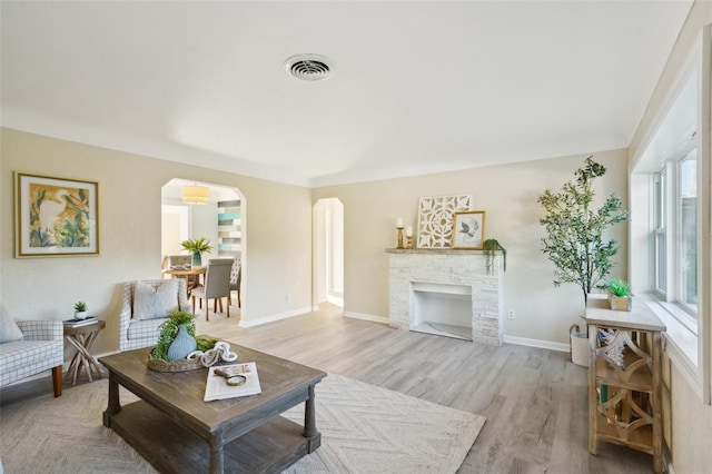 living room featuring light hardwood / wood-style floors and a brick fireplace