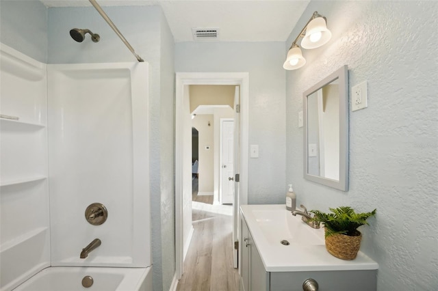 bathroom with vanity, hardwood / wood-style floors, and tub / shower combination