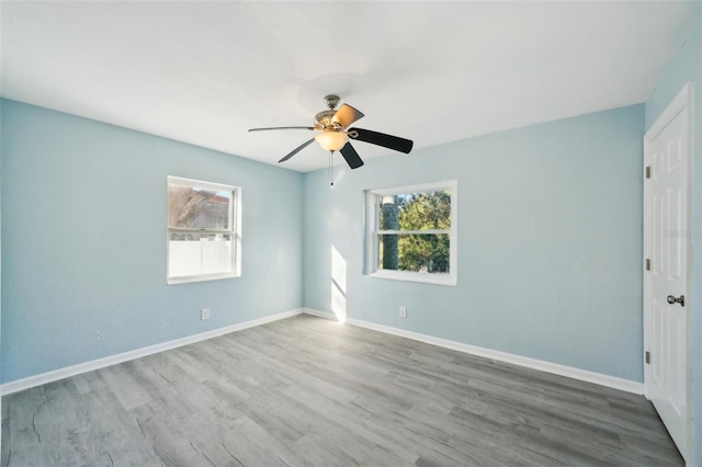 spare room with ceiling fan and light wood-type flooring