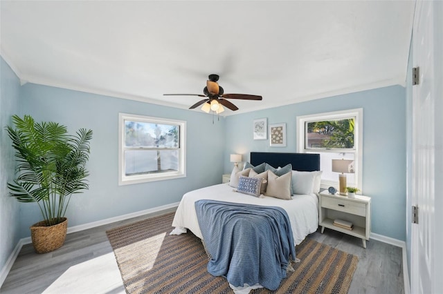 bedroom with ceiling fan, dark wood-type flooring, and crown molding