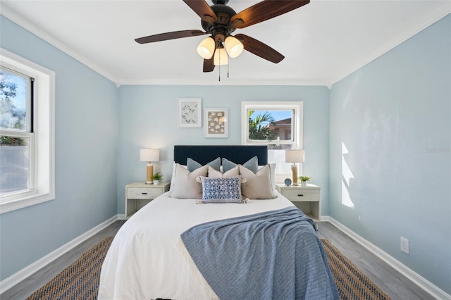 bedroom featuring ornamental molding, hardwood / wood-style flooring, and ceiling fan