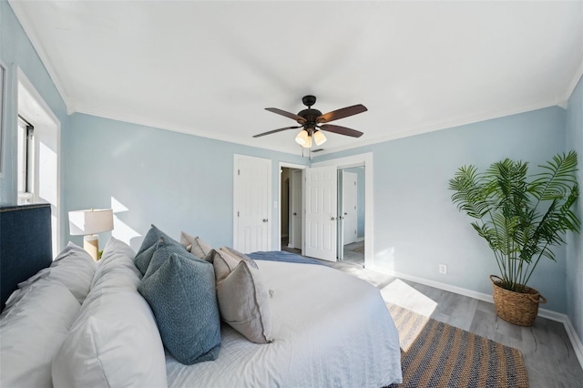 bedroom featuring ceiling fan, hardwood / wood-style flooring, and crown molding