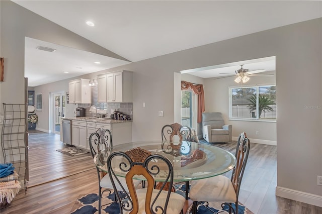 dining room with visible vents, baseboards, light wood-style flooring, vaulted ceiling, and recessed lighting