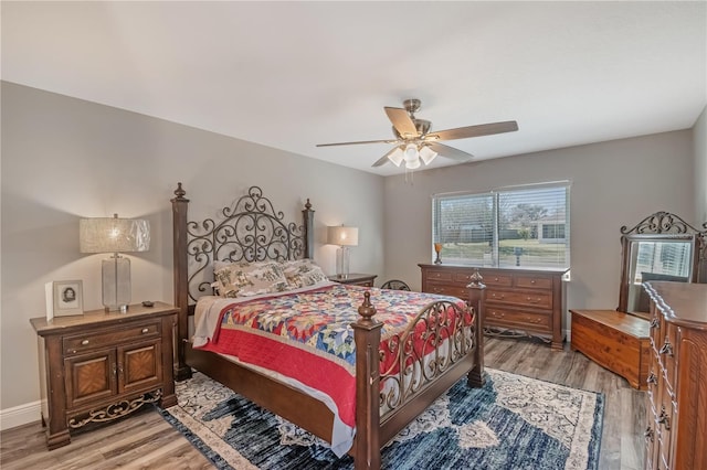 bedroom featuring light wood-style flooring, baseboards, and a ceiling fan