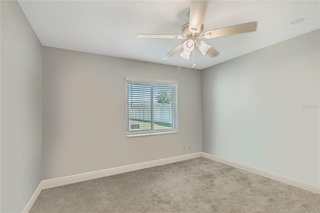 empty room featuring carpet floors, baseboards, and a ceiling fan