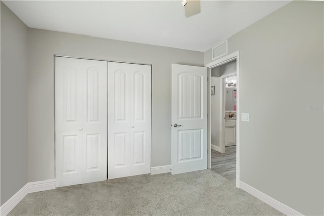 unfurnished bedroom with carpet floors, a closet, visible vents, and baseboards