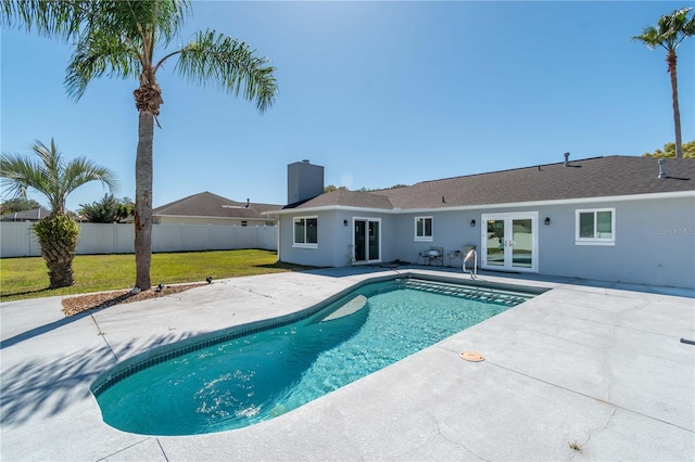 view of pool with a lawn, a fenced in pool, a patio, fence, and french doors