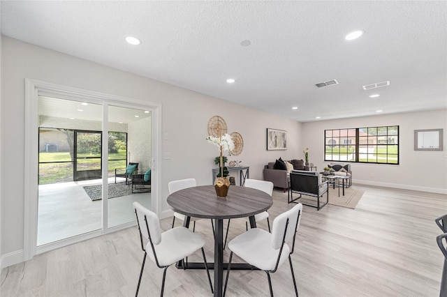 dining area featuring a textured ceiling, recessed lighting, visible vents, baseboards, and light wood finished floors