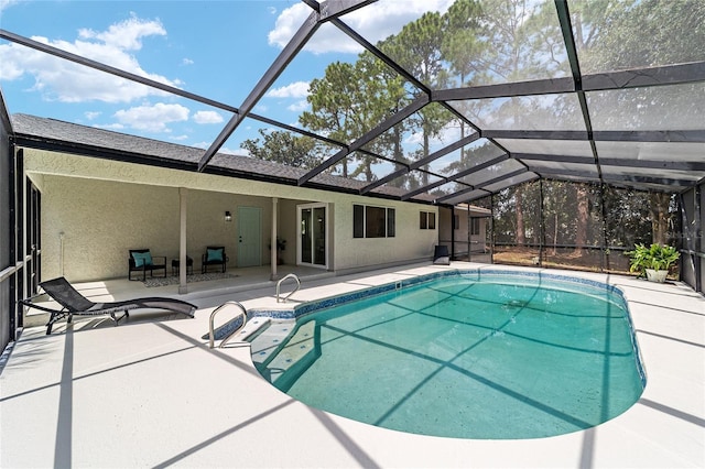 pool featuring glass enclosure and a patio