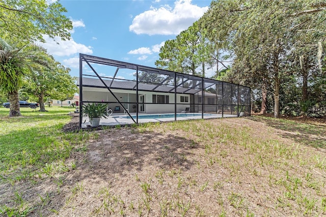 rear view of house featuring a lanai and an outdoor pool