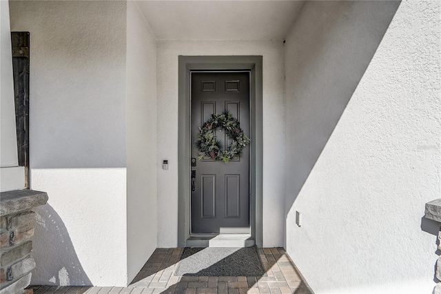 doorway to property featuring stucco siding