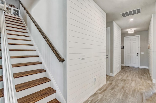 stairway featuring visible vents, baseboards, and wood finished floors