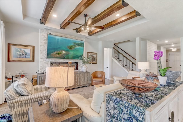 living room featuring ceiling fan, recessed lighting, stairs, light wood-type flooring, and beamed ceiling